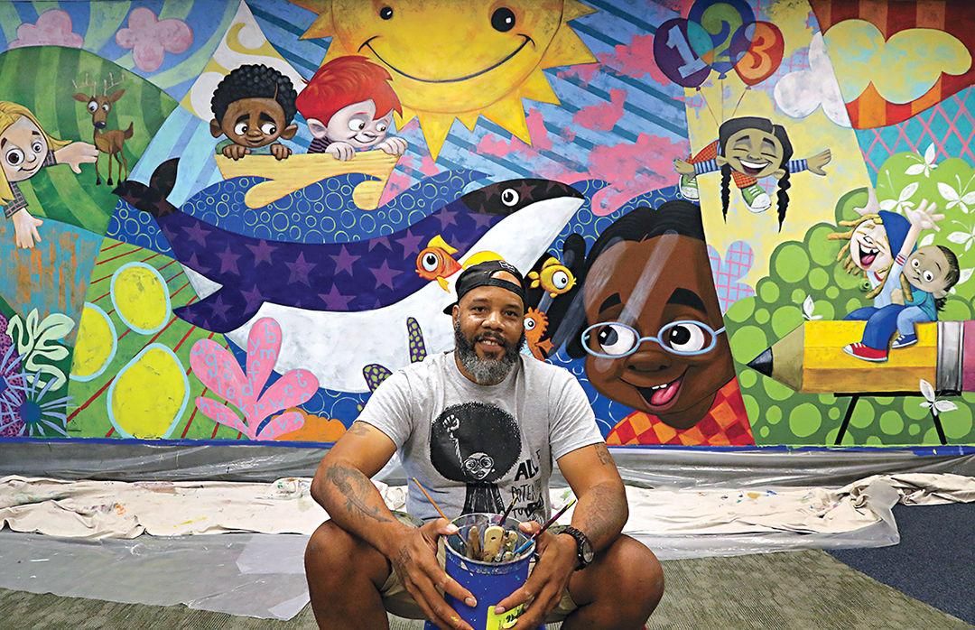 Artist Cbabi Bayoc with his mural-in-progress at Webster Child Care Center